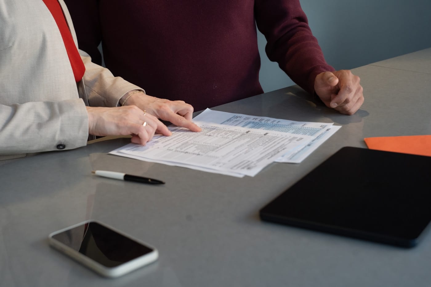 Deux personnes examinent ensemble un dossier papier