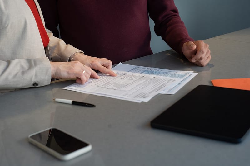 Deux personnes examinent ensemble un dossier papier
