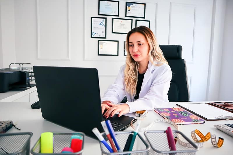 Professionnelle examinant des documents de conformité avant l’achat d’un laser esthétique